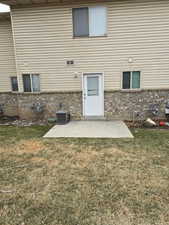 Back of house featuring a yard, central AC, and a patio area