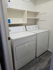 Laundry area with dark wood-type flooring and washing machine and clothes dryer