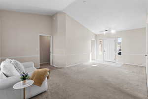 Living room with high vaulted ceiling, light carpet, and a textured ceiling