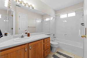 Full bathroom with vanity, shower / washtub combination, tile patterned floors, and toilet