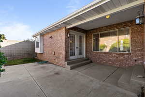 Property entrance featuring french doors and a patio area