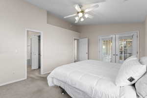 Bedroom with vaulted ceiling, access to outside, light colored carpet, ceiling fan, and french doors