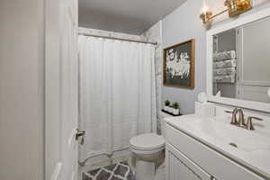 Bathroom featuring vanity, a shower with shower curtain, and toilet