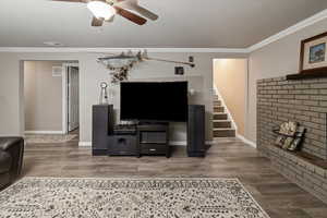 Living room with crown molding, wood-type flooring, and ceiling fan