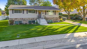 View of front of property with a front yard and central air condition unit