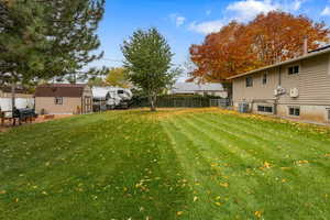 View of yard with cooling unit and a storage shed