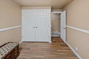 Bedroom featuring dark wood-type flooring and a closet