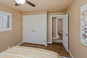 Bedroom featuring ceiling fan, dark hardwood / wood-style floors, and a closet