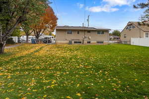 Rear view of property with a lawn