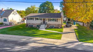 Split foyer home with central AC unit and a front lawn