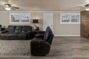 Living room with hardwood / wood-style floors, ornamental molding, and ceiling fan