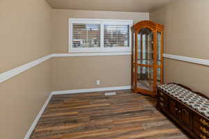 Bedroom with dark hardwood / wood-style flooring