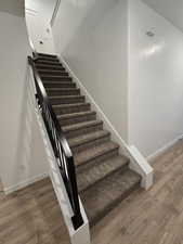 Stairs featuring hardwood / wood-style flooring