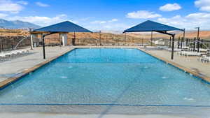 View of swimming pool with a patio, pool water feature, and a mountain view