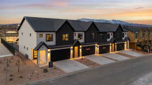 Modern inspired farmhouse featuring a mountain view, a garage, concrete driveway, a residential view, and stucco siding