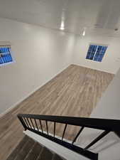 Basement with wood-type flooring and a textured ceiling