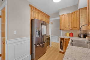 Kitchen featuring sink, stainless steel fridge, range, tasteful backsplash, and hardwood floors