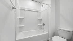 Bathroom featuring bathtub / shower combination and toilet