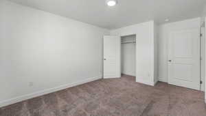 Unfurnished bedroom with carpet flooring and a closet