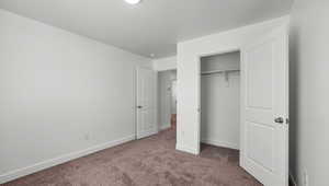 Unfurnished bedroom with carpet flooring and a closet