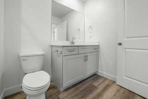 Bathroom with vanity, hardwood / wood-style floors, and toilet