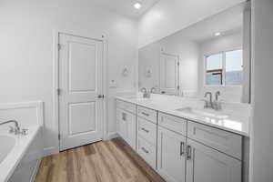 Bathroom with vanity, a bathing tub, and hardwood / wood-style floors