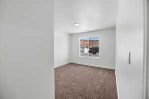 Spare room featuring carpet floors and a textured ceiling