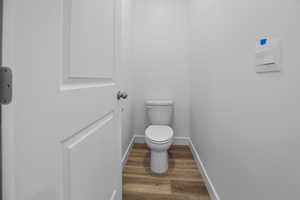 Bathroom featuring wood-type flooring and toilet