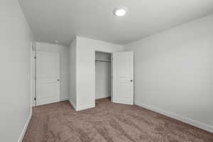 Unfurnished bedroom featuring carpet floors, a closet, and a textured ceiling