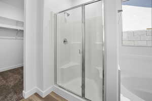 Bathroom with walk in shower, wood-type flooring, and a wealth of natural light