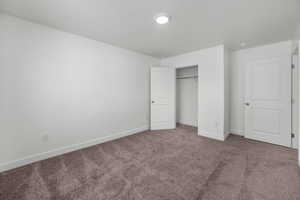 Unfurnished bedroom featuring carpet floors, a closet, and a textured ceiling