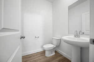 Bathroom with hardwood / wood-style flooring and toilet