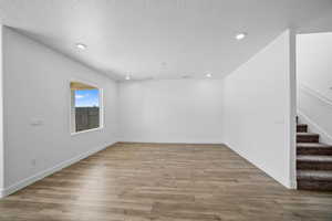 Empty room featuring wood-type flooring and a textured ceiling