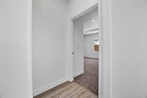 Hallway with light hardwood / wood-style flooring