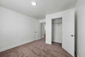 Unfurnished bedroom with carpet flooring, a closet, and a textured ceiling