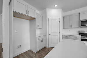 Kitchen featuring stainless steel appliances, light hardwood / wood-style flooring, and a textured ceiling