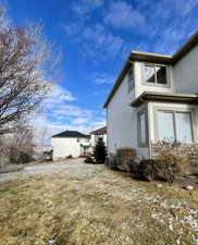 View of side of property featuring central AC unit and a yard