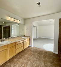 Bathroom with tile patterned floors, vanity, and a shower with shower door