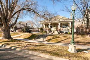 Fall View of front of house featuring  front lawn and large covered porch.