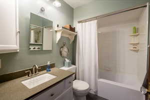 Full bathroom featuring vanity, shower / bath combo Quartz counters.