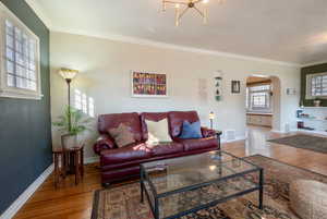 Living room featuring hardwood floors, crown molding.