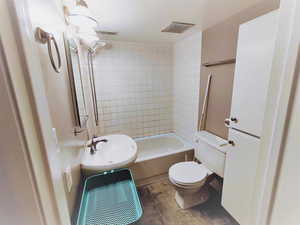 Second view of SAME full bathroom with  toilet, tiled shower / bath combo, and sink.