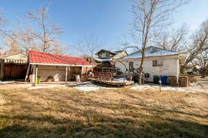 Back of house featuring a deck, out-building.