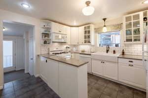 Kitchen featuring white custom cabinetry, gas range,  Quartz  counters.