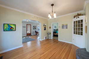 Dining room with built-in hutch crown molding, hardwood flooring.