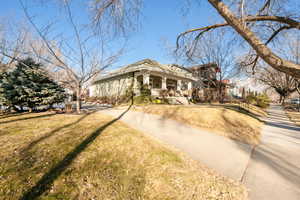 Fall view of front of property with a large expanse of lawn.