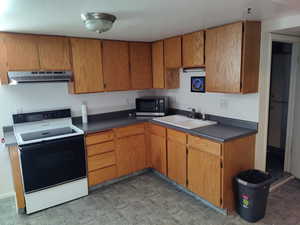 Kitchen featuring ample storage space in many cabinets, electric range