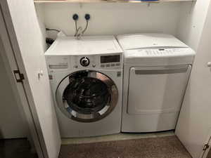 Basement laundry room with washer and dryer included, shelving above washer/dryer.