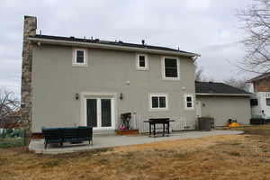 Back of house featuring cooling unit, outdoor lounge area, a patio area, and a lawn