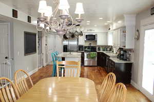 Kitchen featuring tasteful backsplash, a center island, light stone counters, dark brown cabinetry, and stainless steel appliances